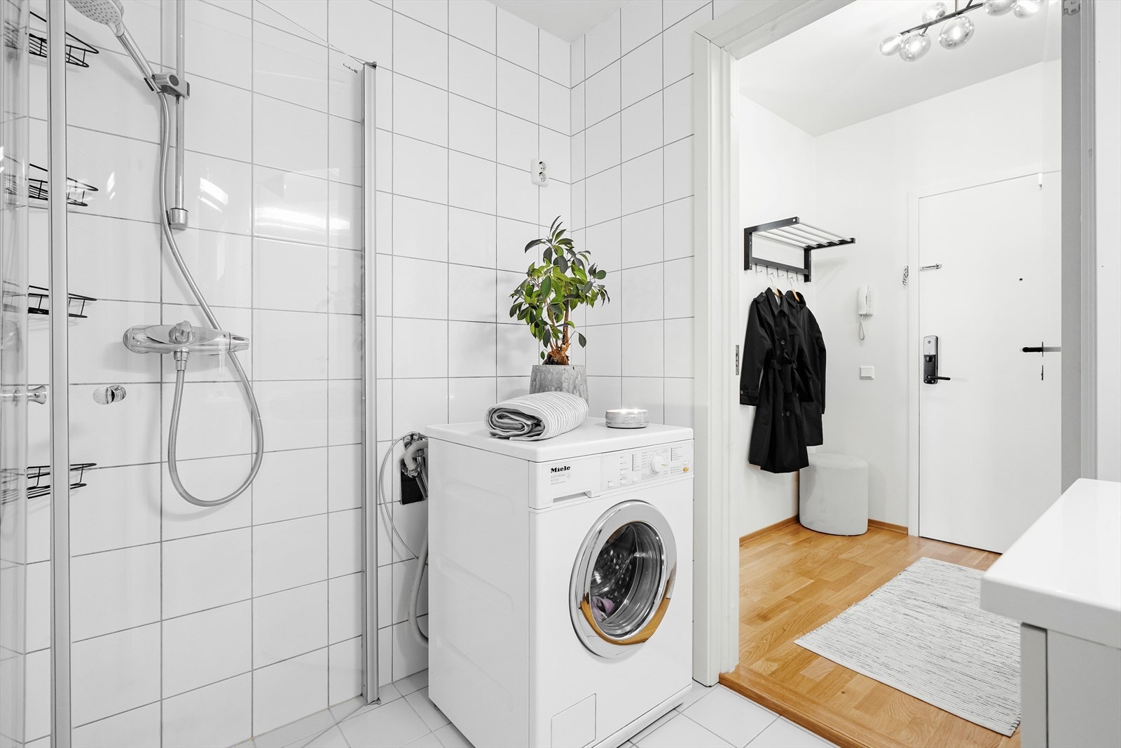 Videre er badet innredet med vegghengt klosett, nedfelt servant i innredning og dusjhjørne med svingbare dører. Vaskemaskinen følger med ny eier. Galleribilde