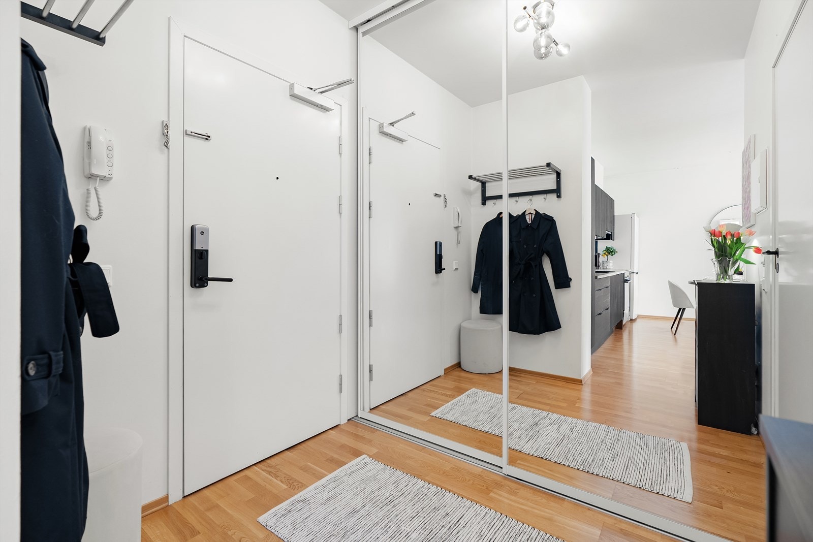 Leiligheten har en innbydende og god entré som skaper et umiddelbart godt førsteinntrykk. Her er det godt med plass til oppbevaring av yttertøy i den romslige skyvedørsgarderoben med speilfronter. Galleribilde