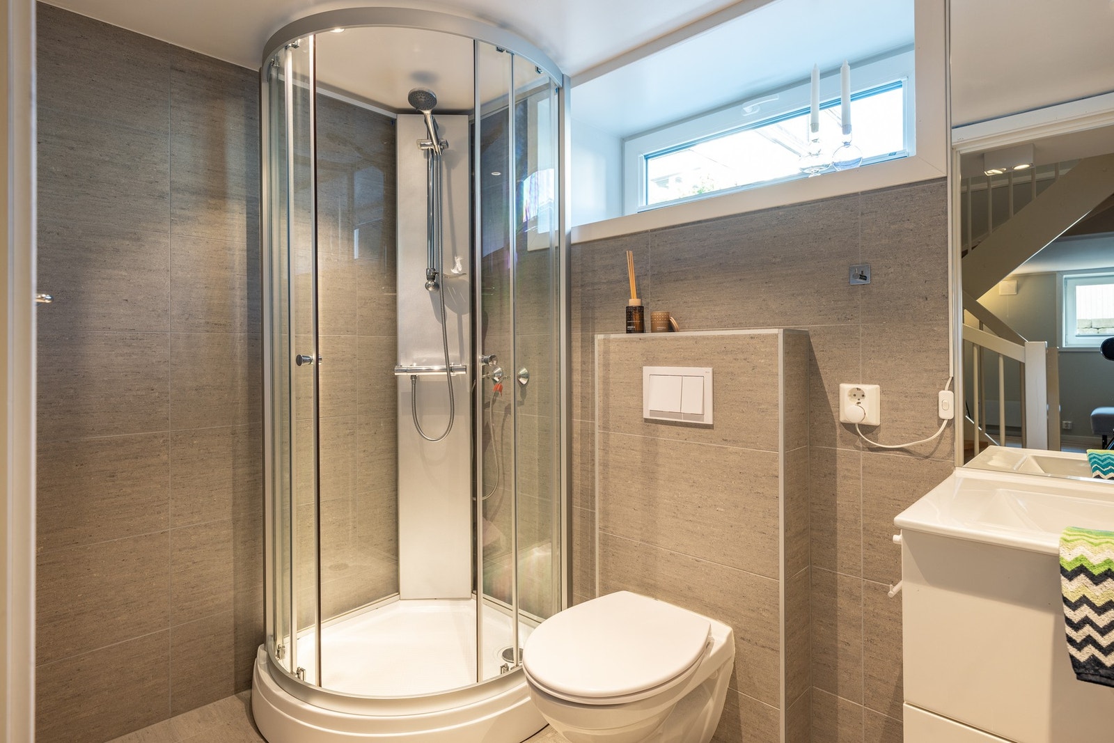 Baderommet har stilige materialvalg, et vindu som slipper inn naturlig lys, og rommer til sammen 3,7 kvadratmeter. Galleribilde