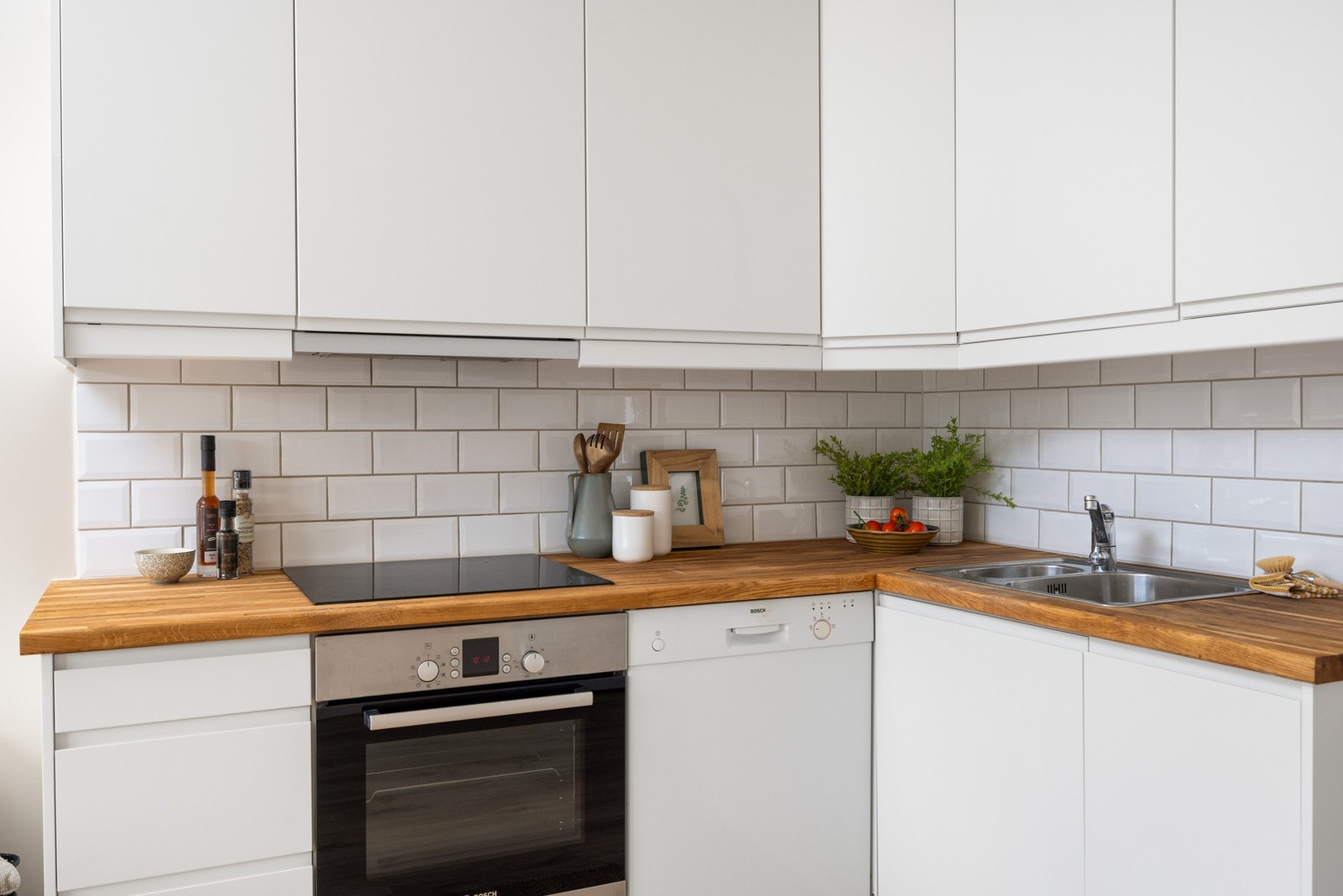 Flott benkeplate i eik. På veggen over benkeskapene er det lagt fliser. Galleribilde