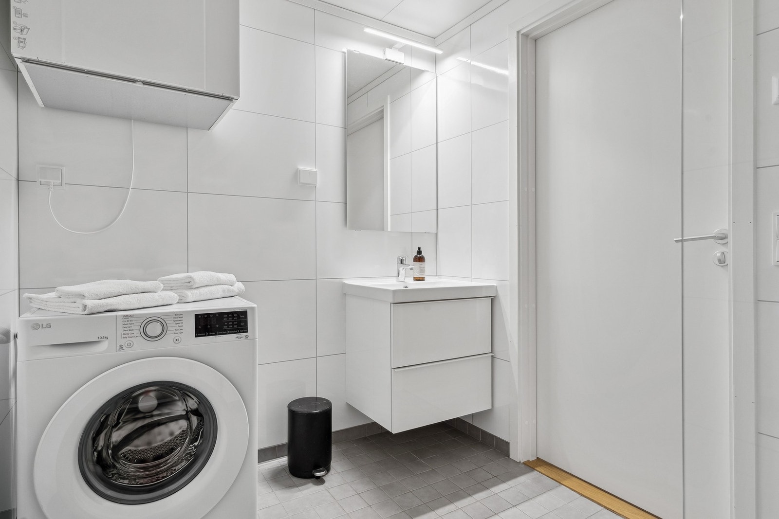 Bad med lyse overflater og innredninger, opplegg for vaskemaskin Galleribilde