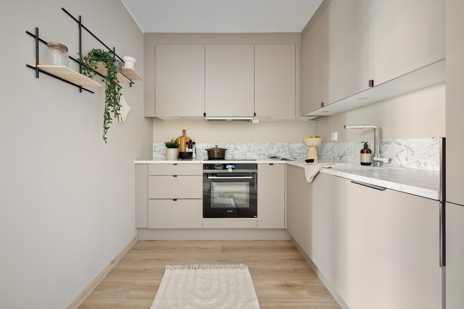 Kjøkkenet har innredning med grå glatte fronter. Benkeplaten er av laminat. Galleribilde