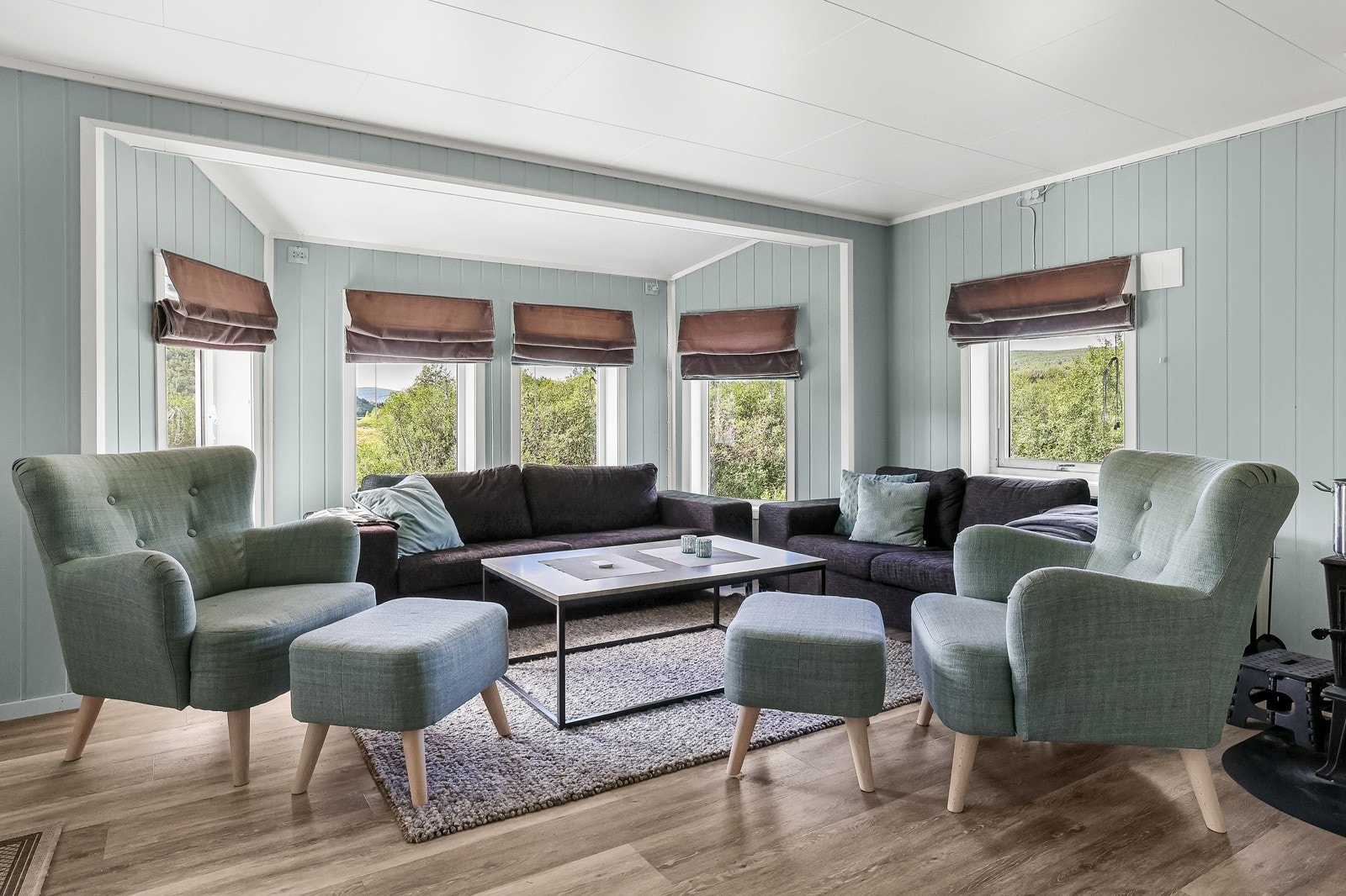 Stuen har flere vindusflater som gir rommet rikelig med naturlig lysinnslipp Galleribilde