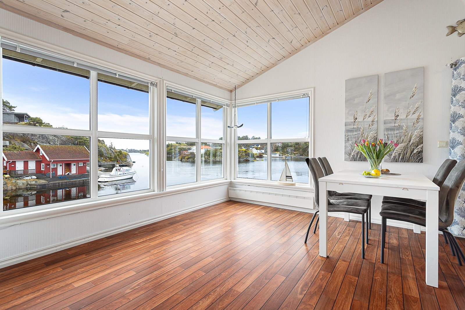 Stue med store vindusflater mot sjøen. Galleribilde
