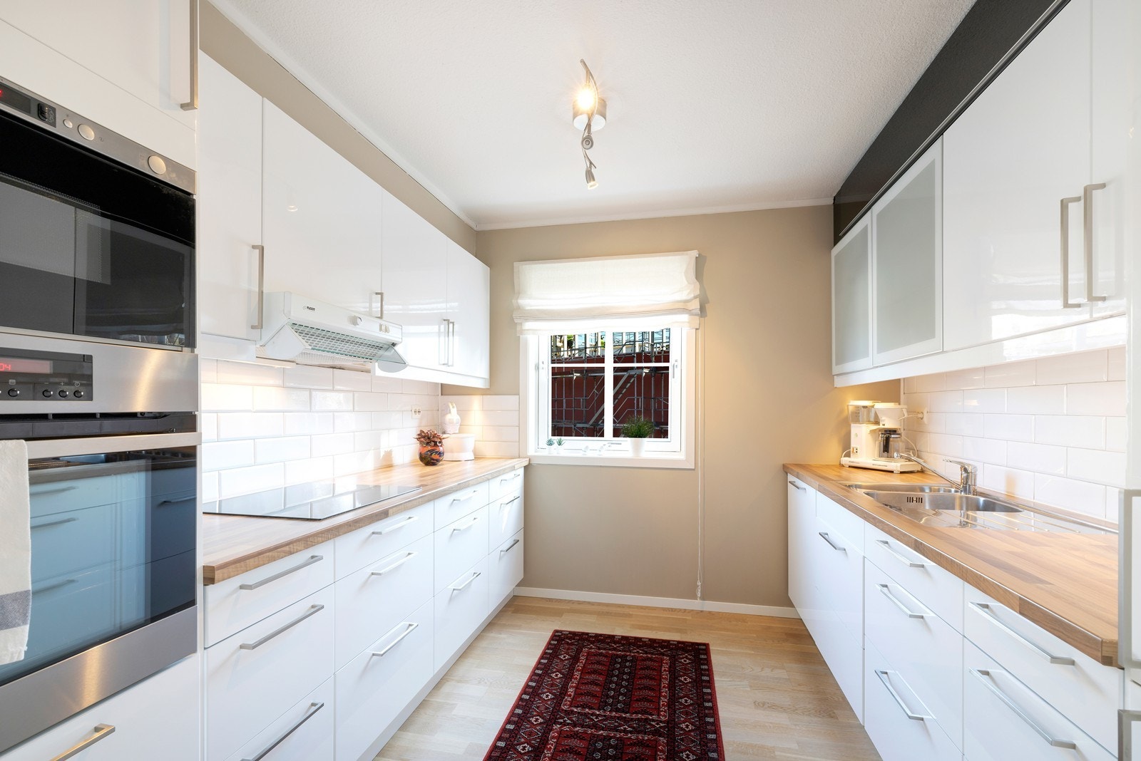 Pent kjøkken med mye skap- og benkeplass Galleribilde