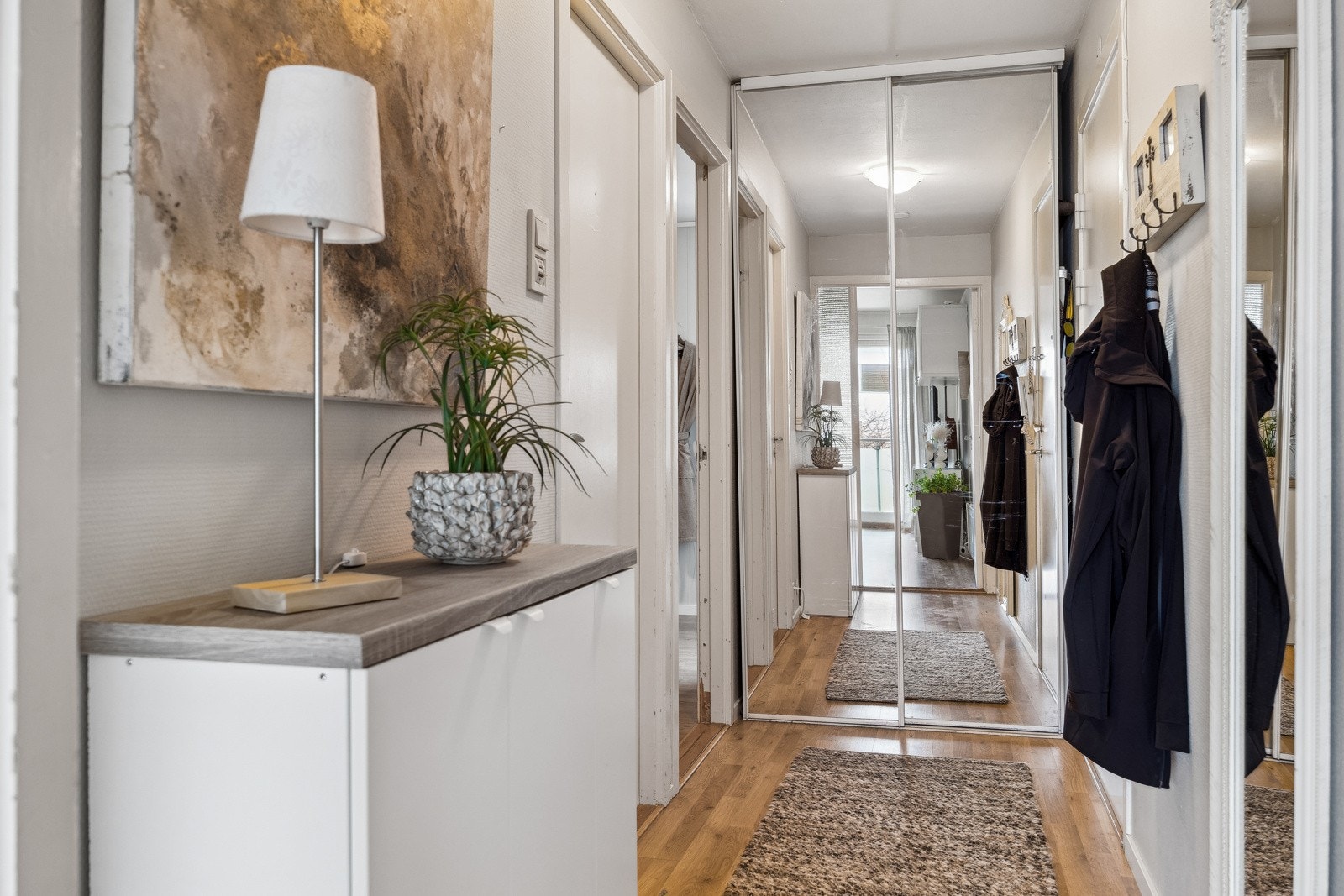Flott entrè med skyvedørsgarderobe m/speilfronter i enden av gangen. Galleribilde