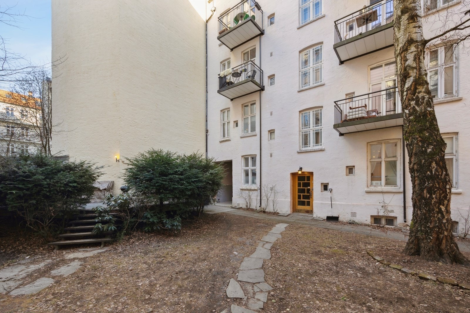 Pent opparbeidet og stensatt felles gårdsrom med sittegrupper og diverse beplantning. Galleribilde