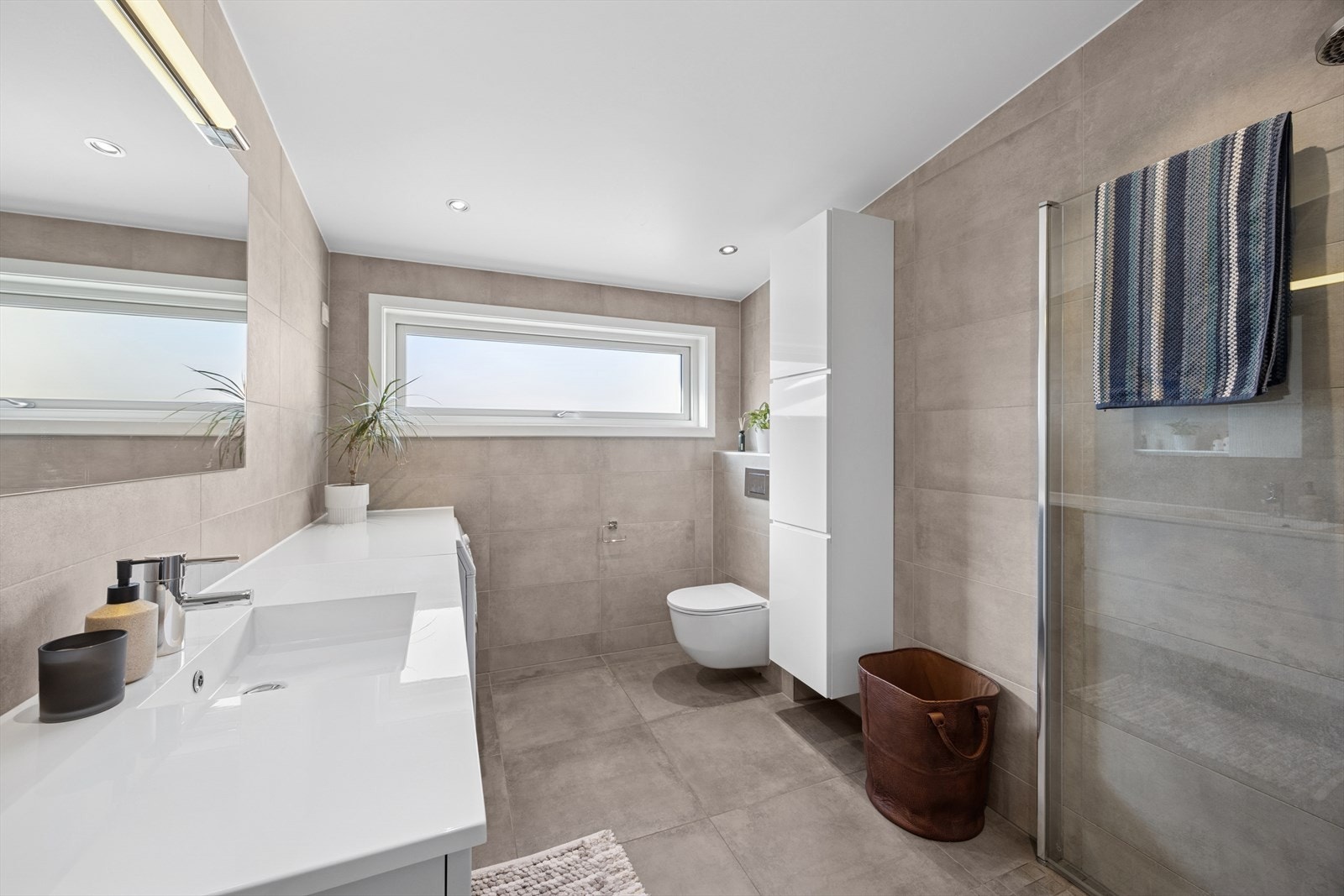 Badet er nytt fra 2019 og er flislagt med pene, beige fliser. Rommet er utstyrt med varmekabel i gulv og LED downlights i himling. Galleribilde