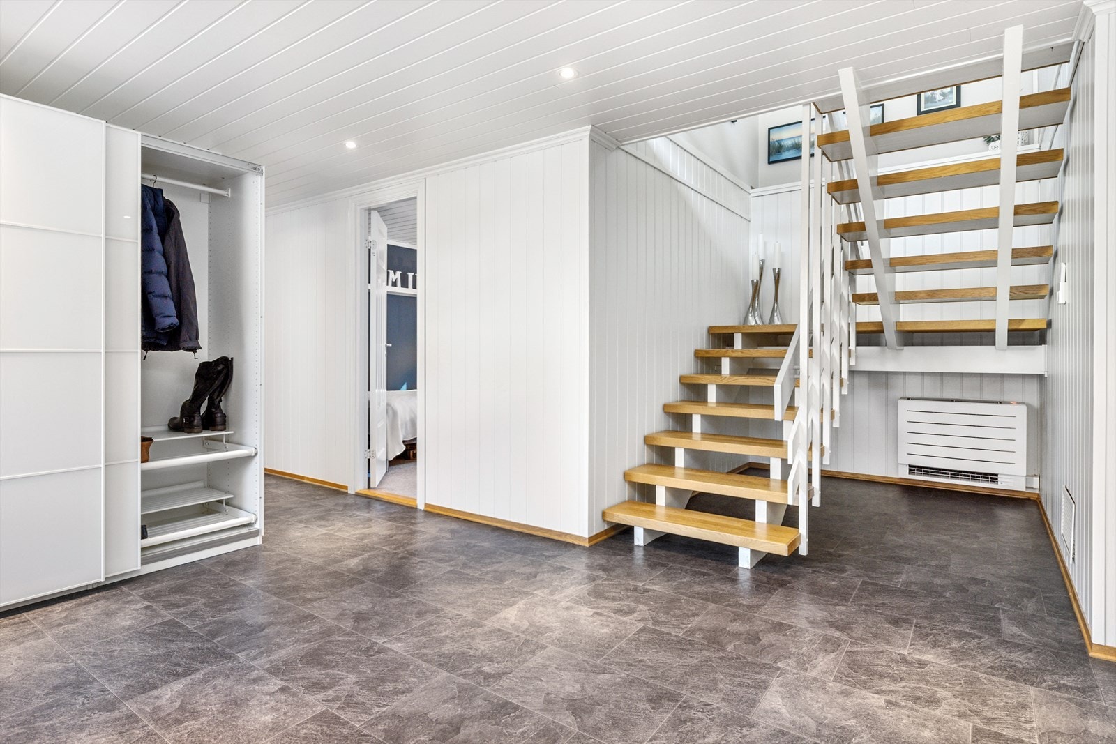 Romslig hall med god plass til å henge av seg klær og sko, her er det montert en varmepumpe for effektiv oppvarming Galleribilde
