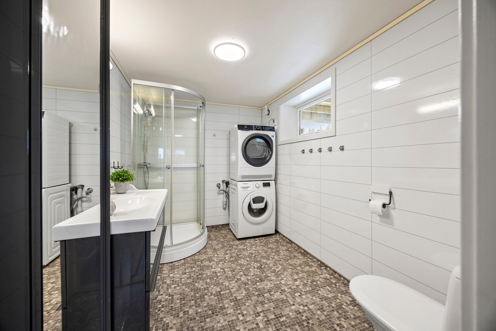 Bad/vaskerom - 7 kvm. Utstyrt med servantskap, dusjkabinett, toalett og opplegg for vaskemaskin Galleribilde