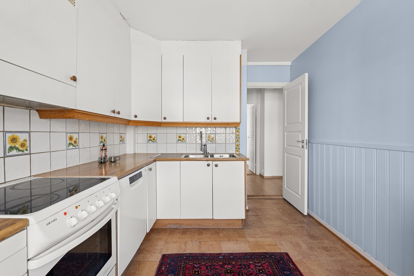 Av hvitevarer byr kjøkkenet på komfyr, oppvaskmaskin, og kjøl/fryseskap. Galleribilde