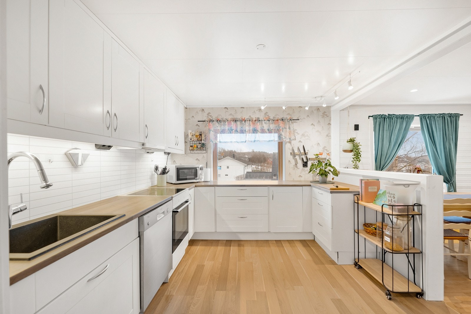 Hvitevarer er frittstående og det er opplegg for oppvaskmaskin. Benkeplaten er av den romslige sorten som innbyr både matlaging og baking Galleribilde