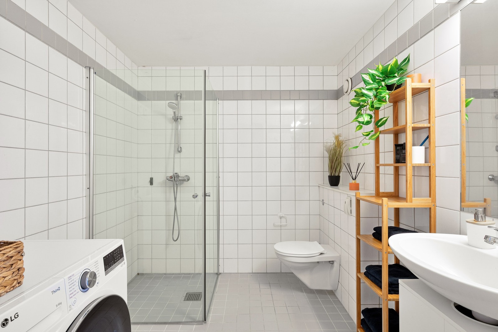 Flislagt bad med varme i gulv. Det er opplegg for vaskemaskin. Galleribilde