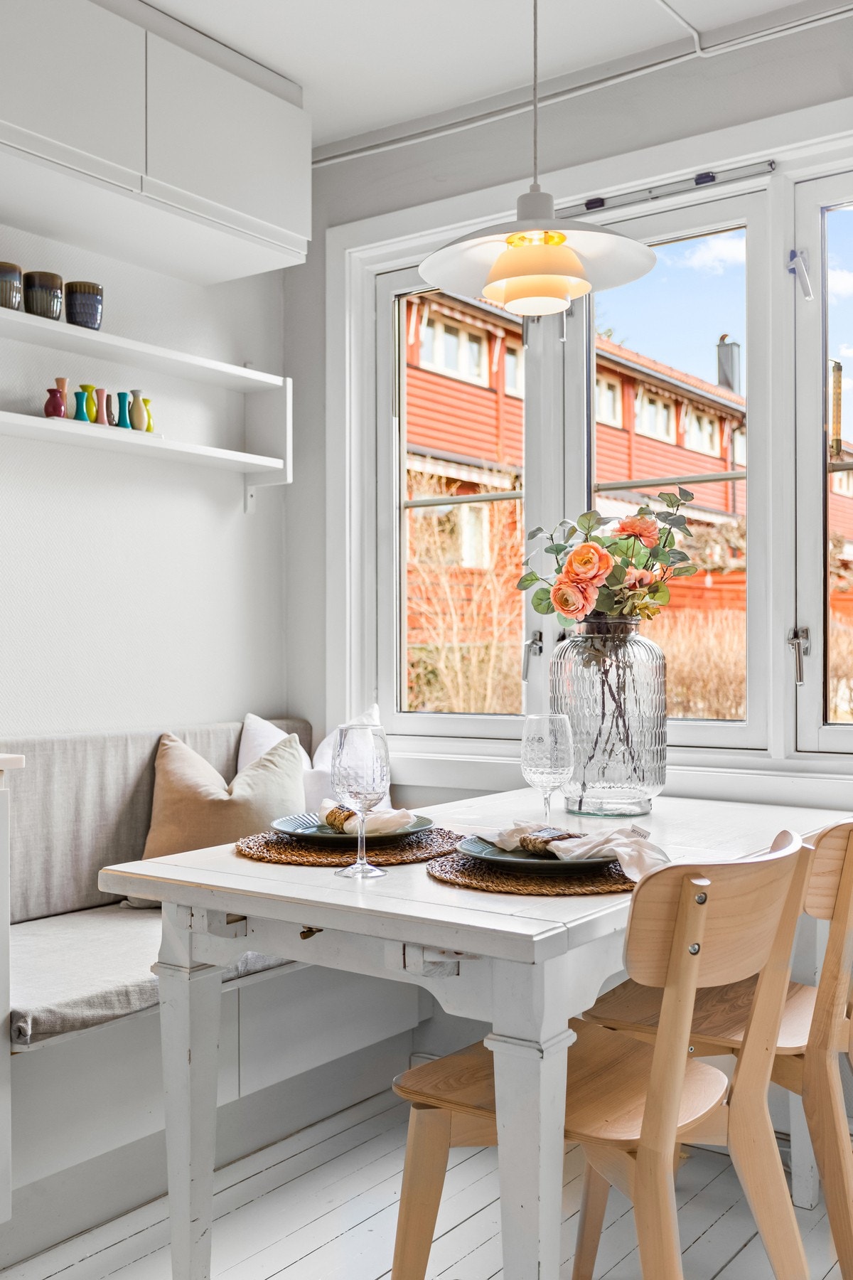 Kjøkkenet har en hyggelig spiseplass ved vinduet, hvor man ser ut på tunet. Sittebenk med skuffer for lagring. Galleribilde
