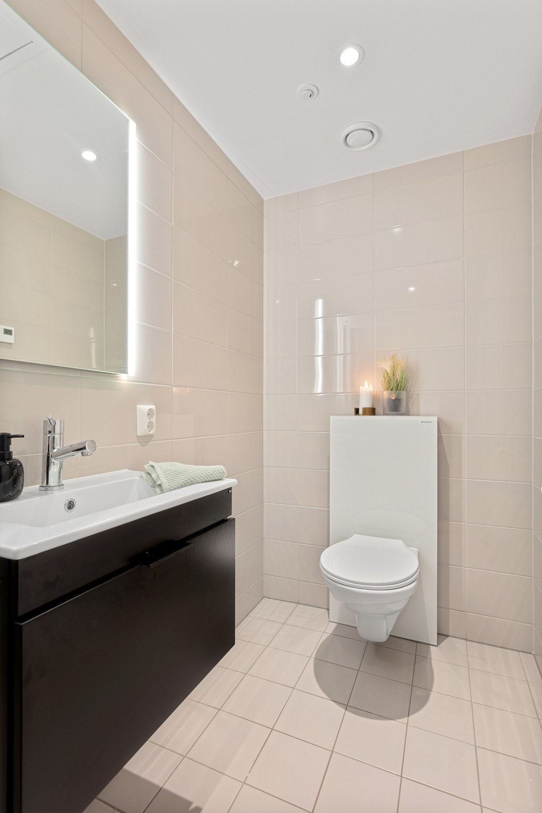 Det andre badet er tilknyttet soverommet. Badet er flislagt med gulvvarme og har vegghengt toalett, dusj med dusjvegger samt servantskap i sort utførelse og speilskap. Galleribilde