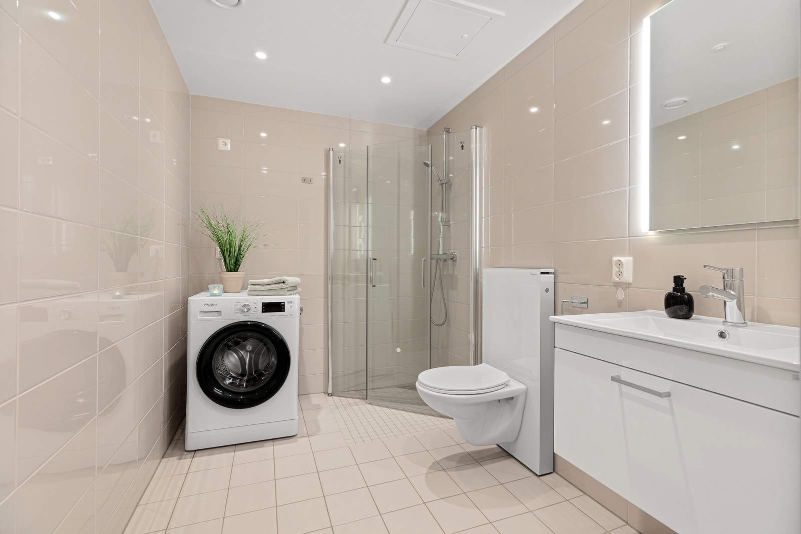 Leiligheten har to bad. Badet med tilgang fra gang er flislagt med gulvvarme, vegghengt toalett, innfellbare dusjdører, godt med speilskap, underskap og opplegg og plass for vaskemaskin og tørketrommel. Galleribilde