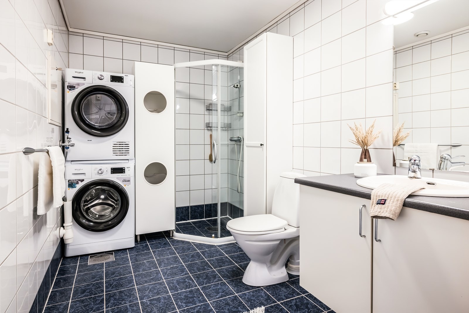 Pent baderom med opplegg for vaskemaskin og tørketrommel. Galleribilde