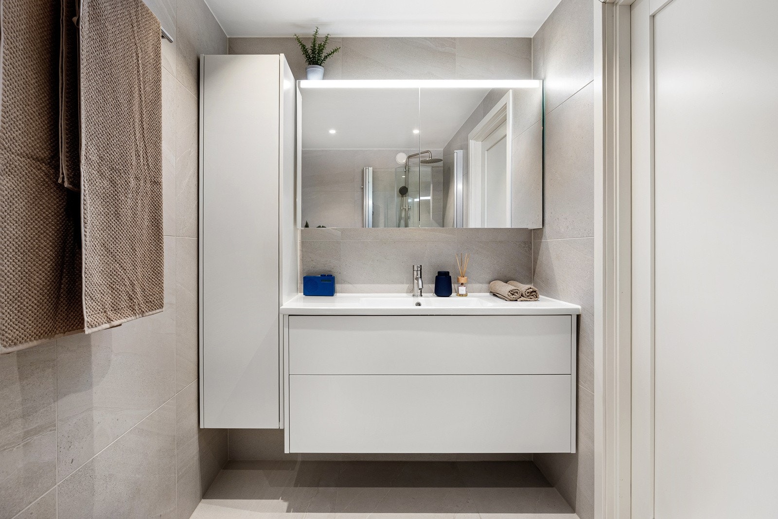 Badet tilknyttet hovedsoverommet er lyst og moderne fra 2019 med flislagte overflater, gulvvarme og downlights. Galleribilde