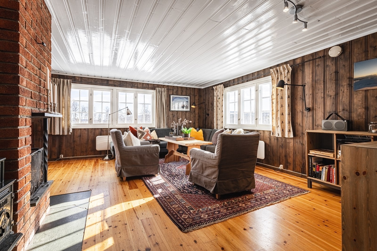 Romslig stue med store vindusflater og god plass til flere sittegrupper. Galleribilde