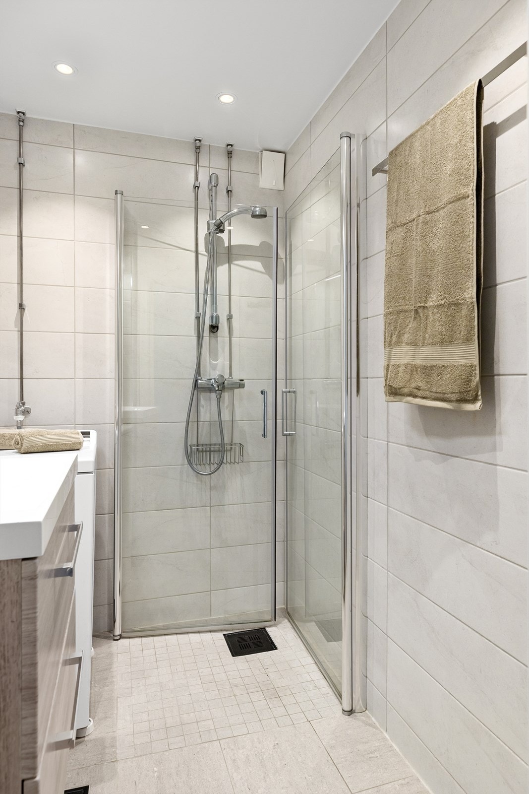 Badet er innredet med en praktisk dusjplass med inn- og utadslående dusjvegger, servant med ettgreps blandebatteri integrert i innredningen, samt opplegg for vaskemaskin Galleribilde