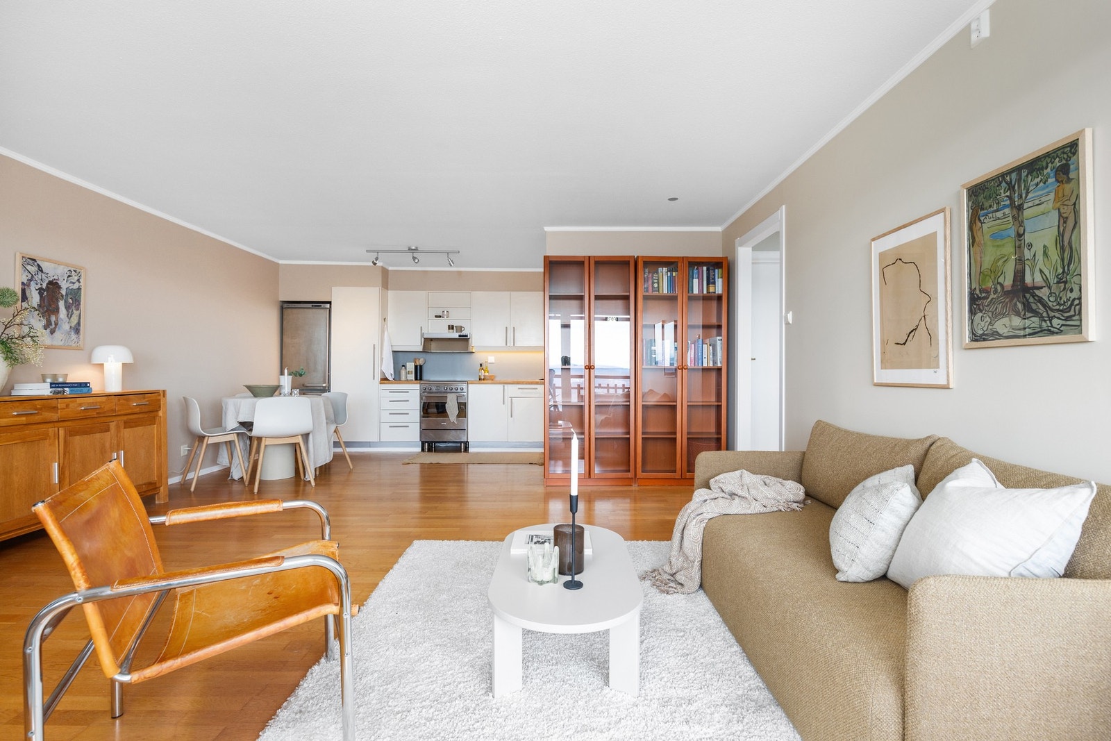 Stuen mot kjøkkenet som ligger i en åpen, men tilbaketrukket løsning. Noe modernisering må forventes. Galleribilde