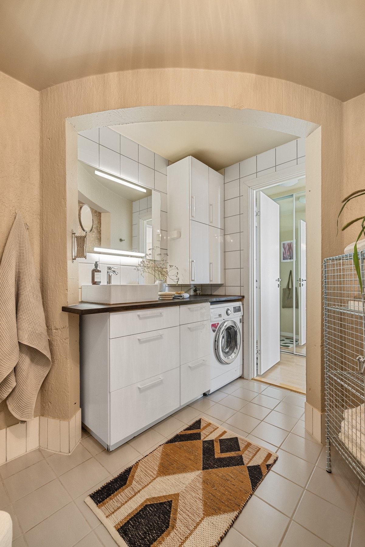 Servantinnredning med heltre benkeplate og ovenpåliggende servant, samt godt med skap og skuffer. Speil med belysning på vegg over servant. Galleribilde