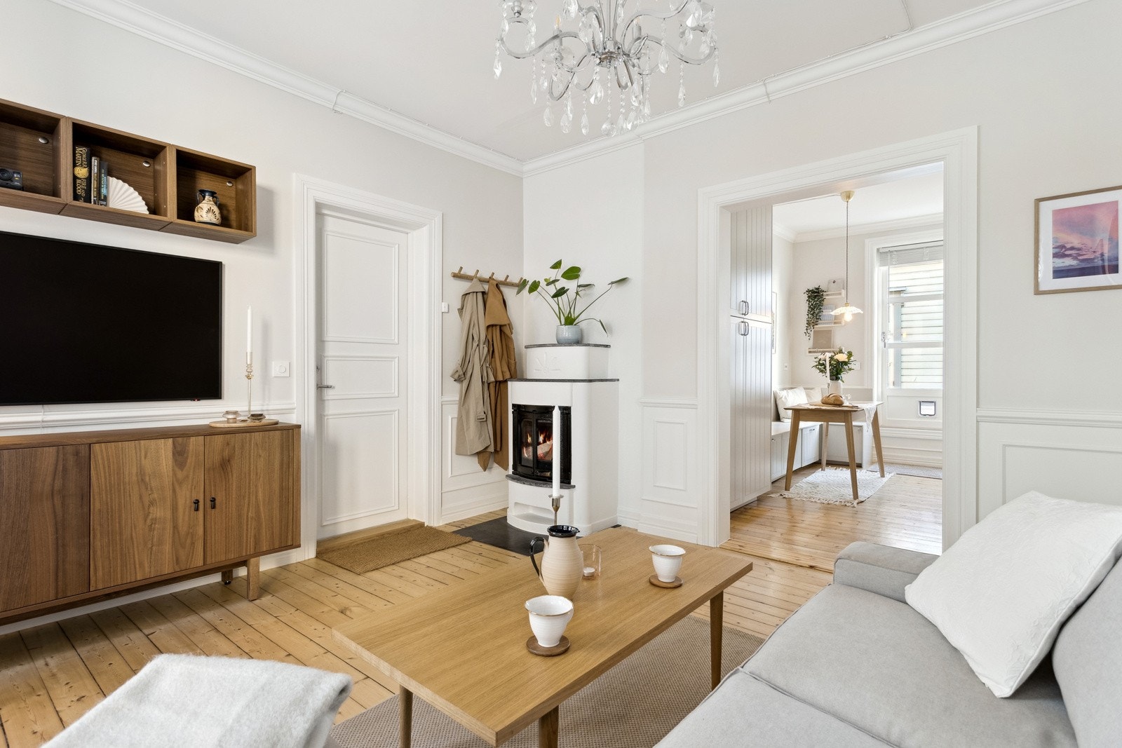 Stuen er malt i lyse og behagelige fargevalg og fremstår moderne og lekker. De høye listene tilfører både dybde og karakter til rommet Galleribilde