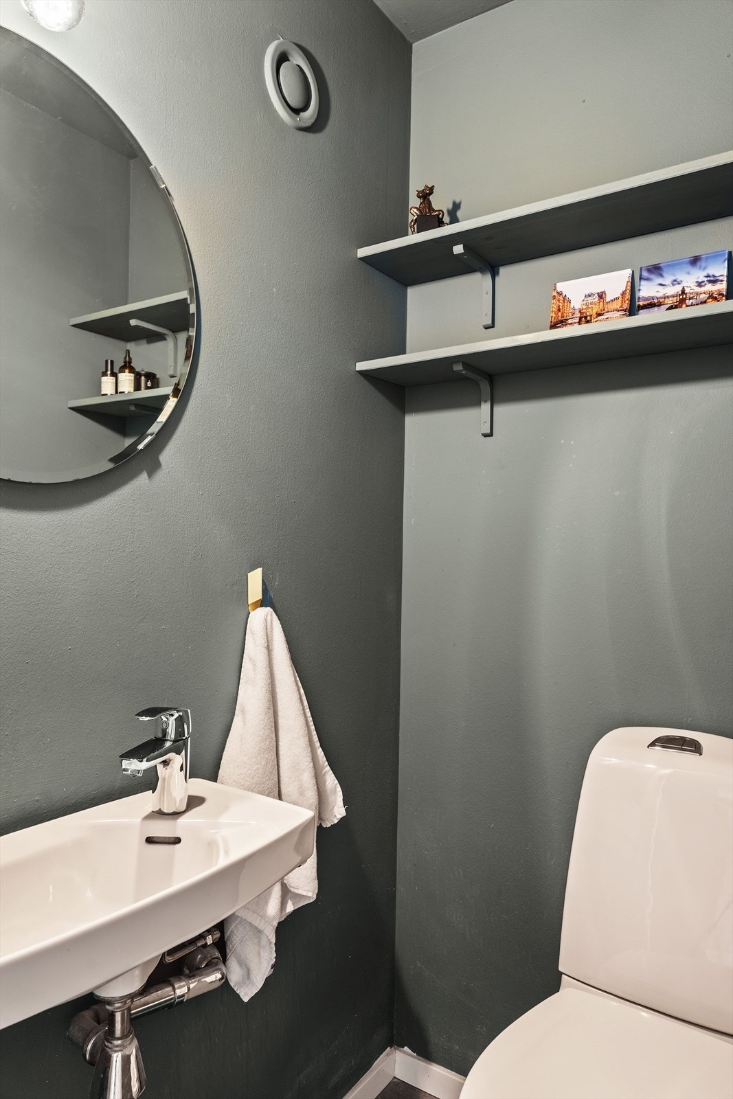 Leiligheten har et separat toalettrom med inngang fra entre. Innredningen består av vegghengt servant, hylleløsning, speil med overbelysning og et gulvstående toalett. Galleribilde