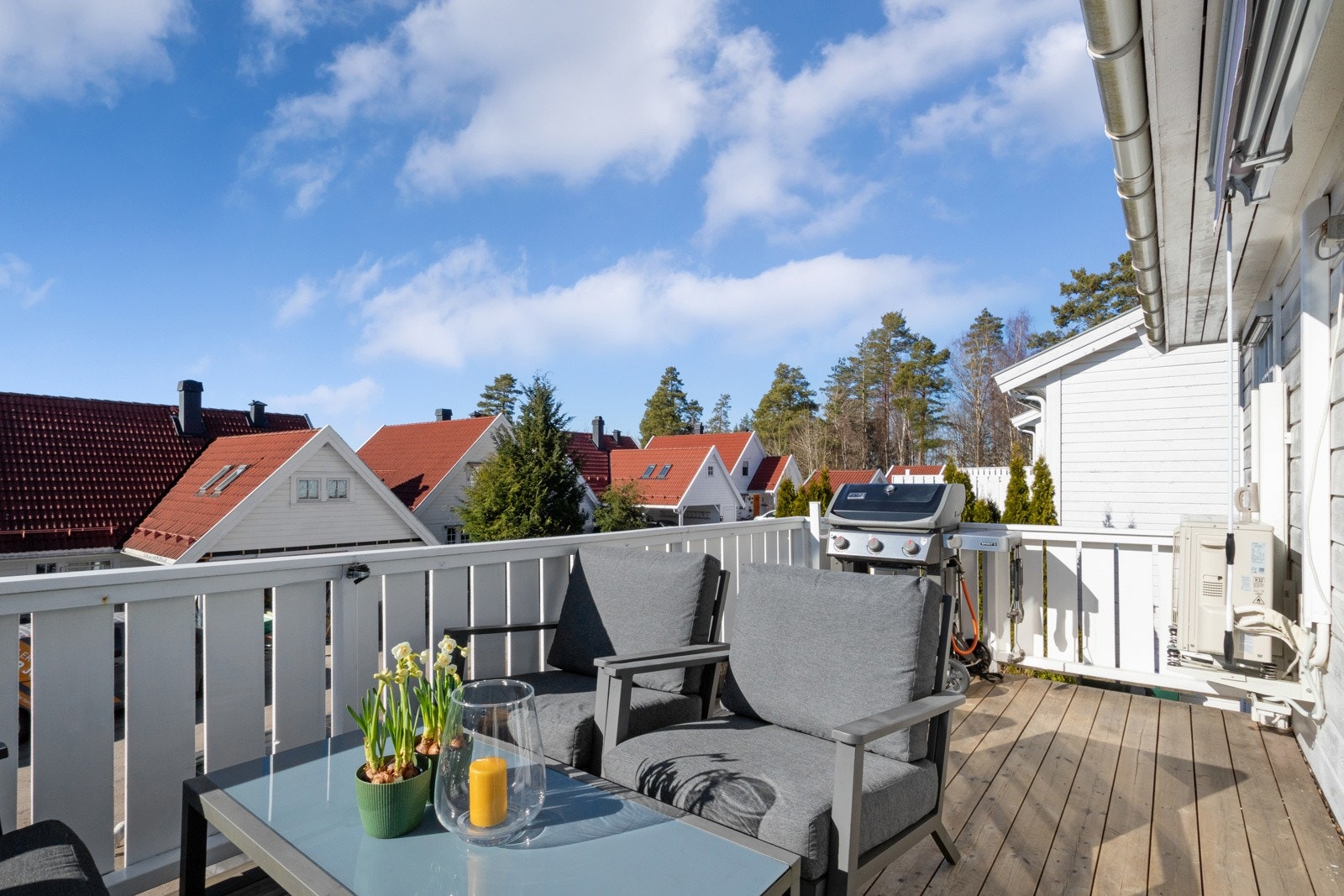 Balkongen har dekke og rekkverk i tre, og det er utelys og en markise fra 2021 på husveggen. Galleribilde