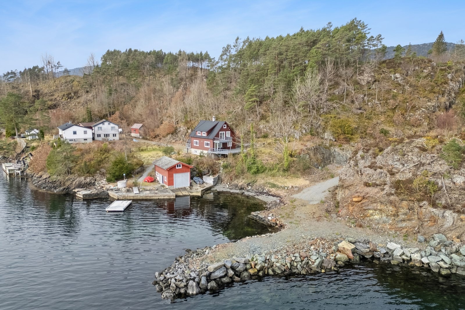 Tomten er delvis opparbeidet og planert med vei, parkeringsplasser og molo. Molo er planert med grove steinmasser. Ref. reguleringsplan er det godkjent servicebygg og naust. Galleribilde