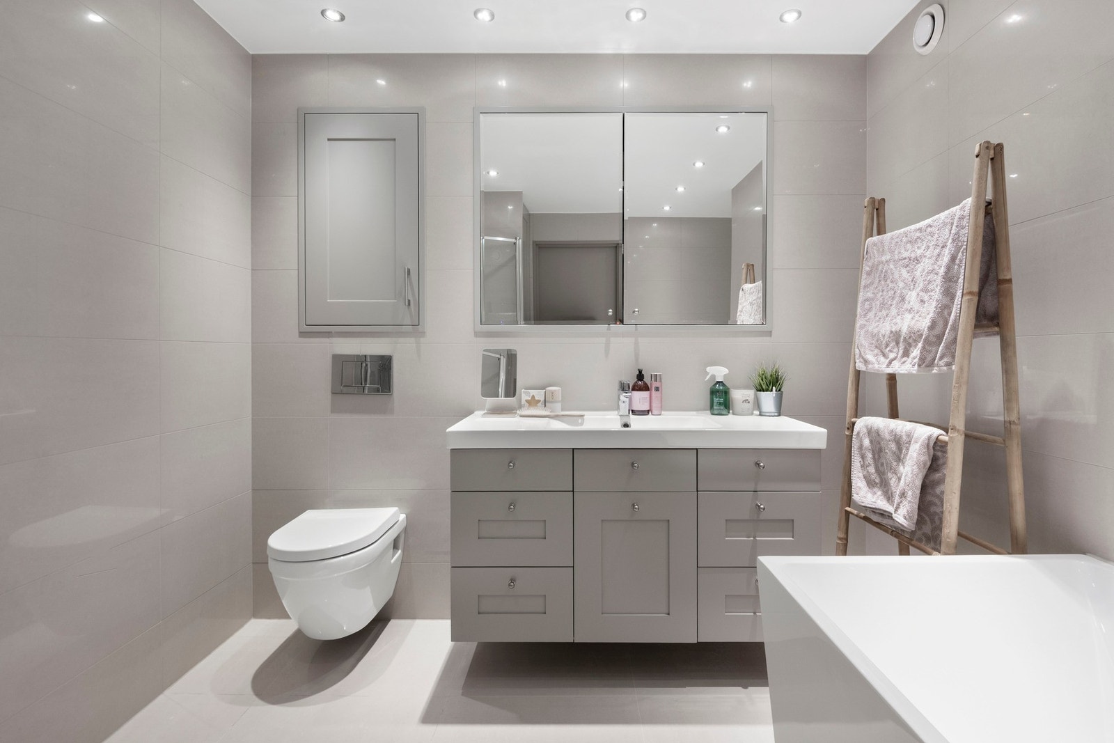 Badet har vegghengt servantinnredning med skuffer og ovenpåliggende servant samt speilskap over servant. Galleribilde