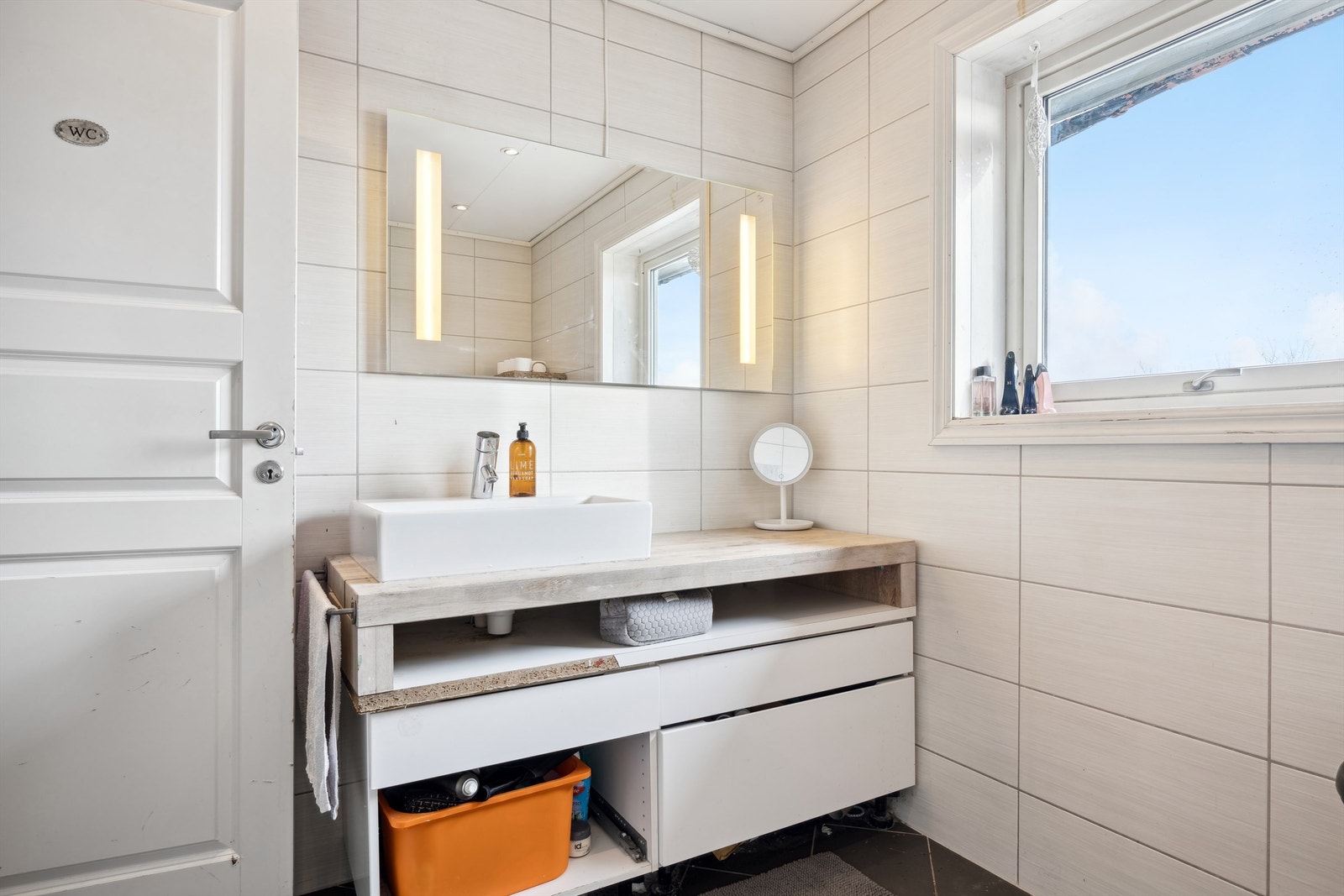 Badet er utstyrt med gulvstående servantinnredning og et stilfullt speil med sidelys, som gir et moderne og funksjonelt preg. Galleribilde