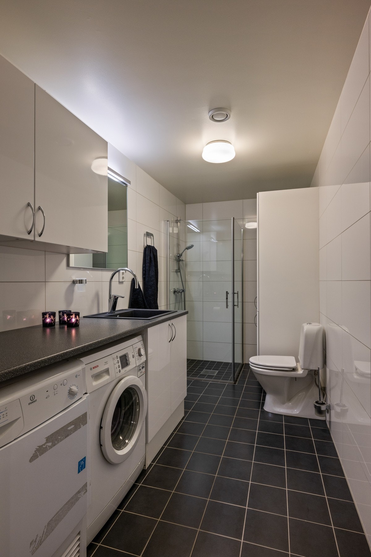 Lyst og praktisk bad med vaskeromsløsning i første etasje. Galleribilde