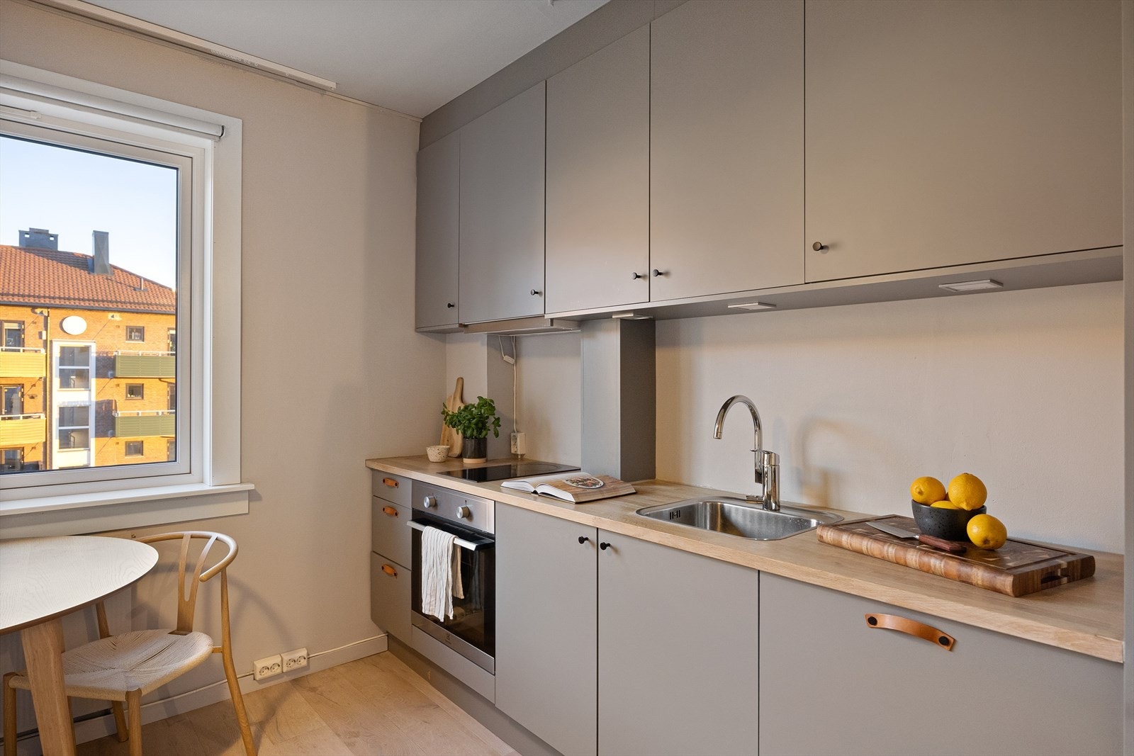 Kjøkkenet har en stilrent, glattlaminert innredning med integrert belysning under overskap. Galleribilde