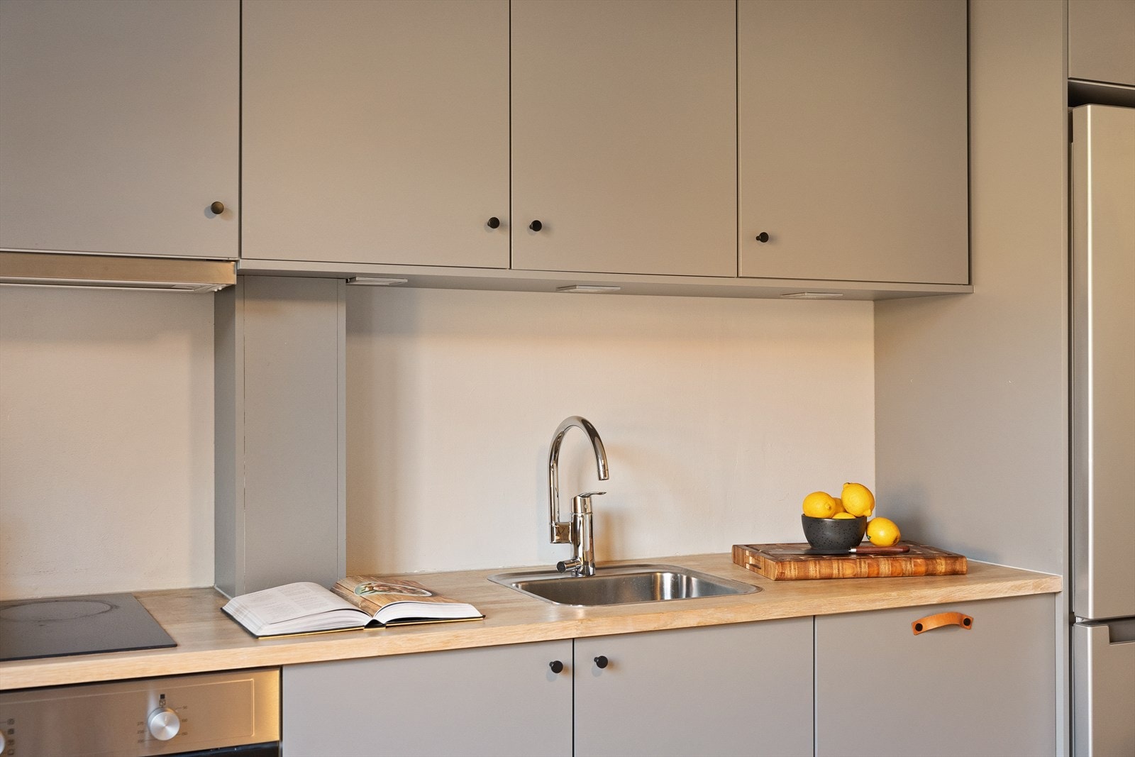 Videre har kjøkkenet en benkeplate i tre, en kum med ettgreps blandebatteri og en integrert oppvaskmaskin. Galleribilde