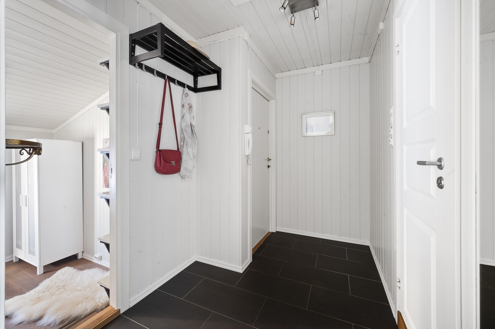 Flislagt entre med muligheter for løsninger til oppbevaring og klesoppheng. Galleribilde