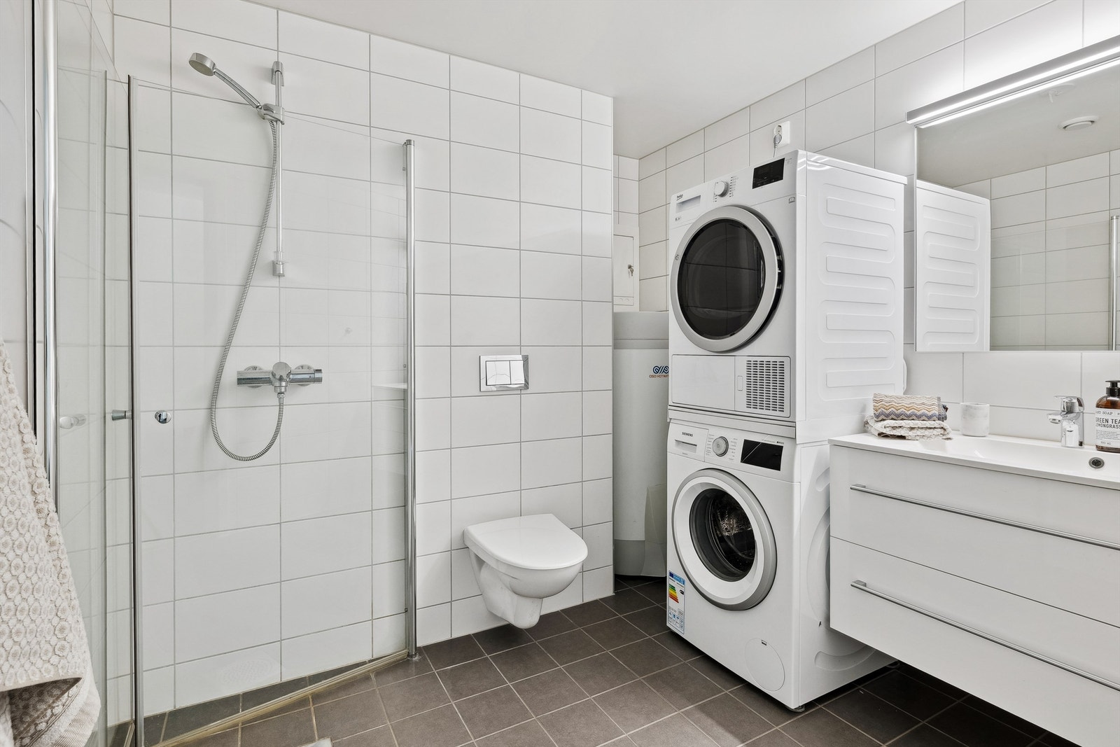 Bad med flislagte gulv med varme, flislagte vegger og malt overflate i himling Galleribilde