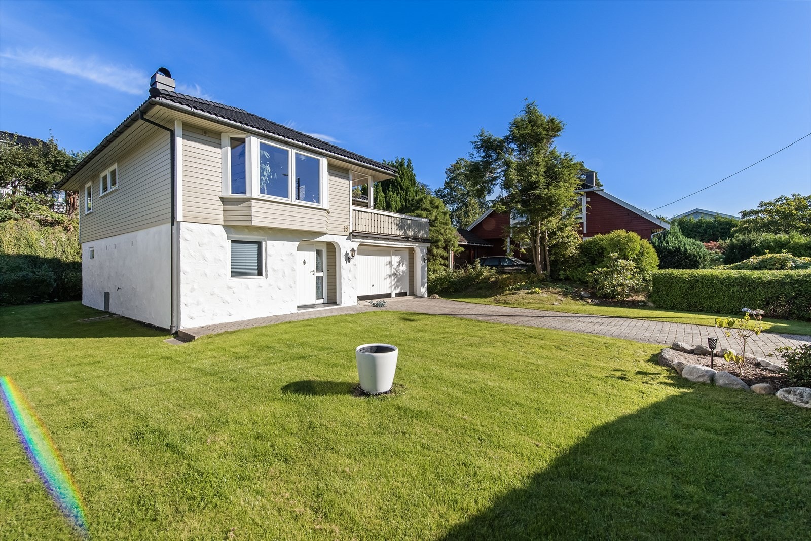 Her får du det beste av to verdener - en tomt med både opparbeidede blomsterbed og frodige trær. Galleribilde