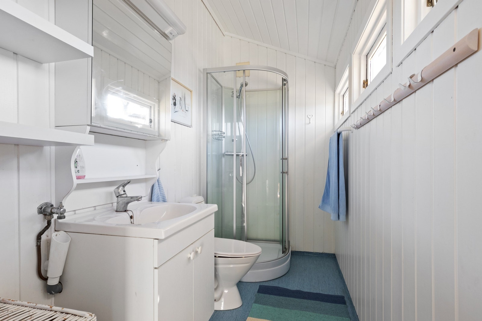 Badet er innredet med opplegg for vaskemaskin, toalett, innredning med nedfelt servant og speil. Galleribilde