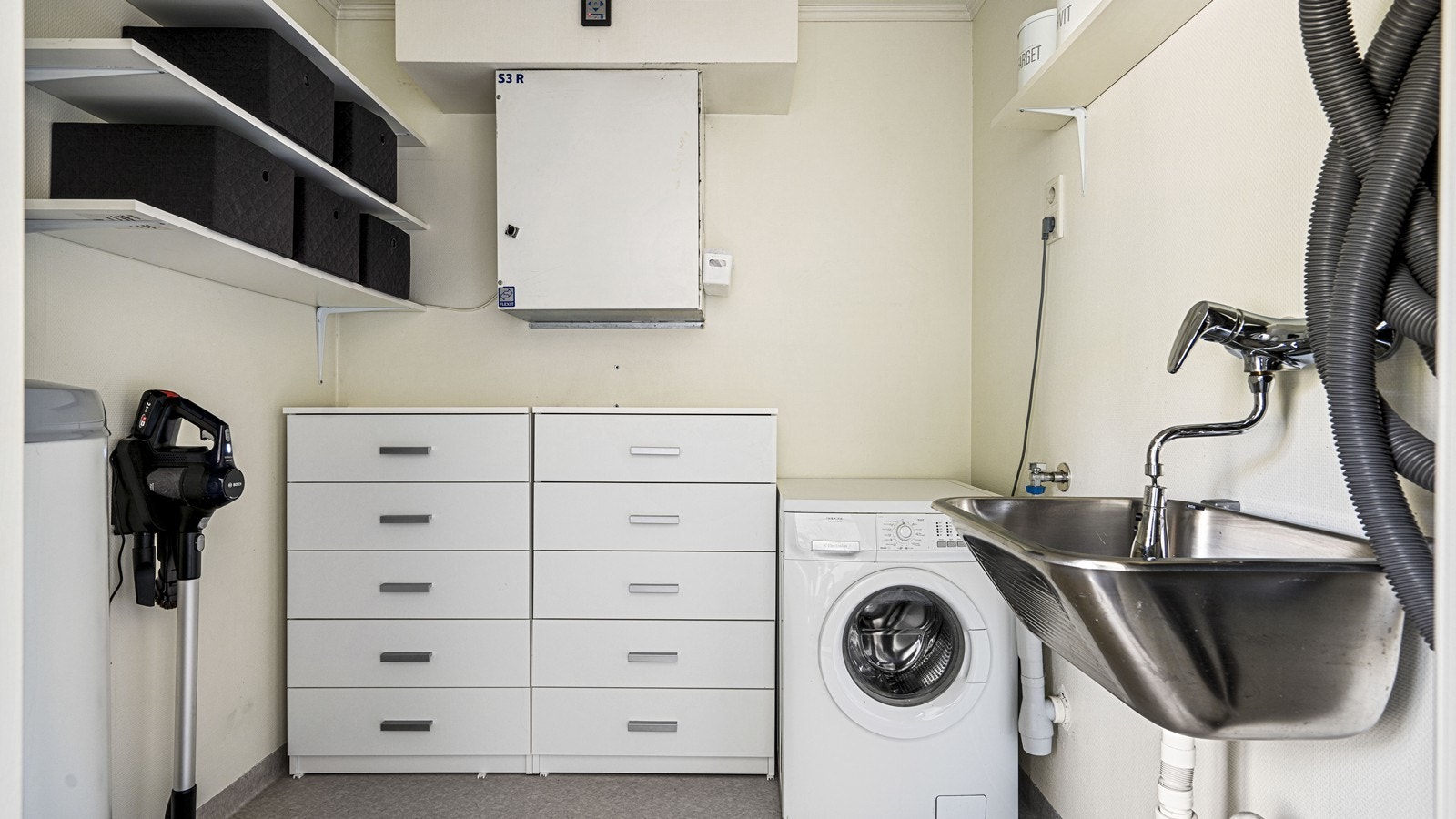 Eget vaskerom tilknyttet badet - her er det utslagsvask og opplegg til vaskemaskin Galleribilde