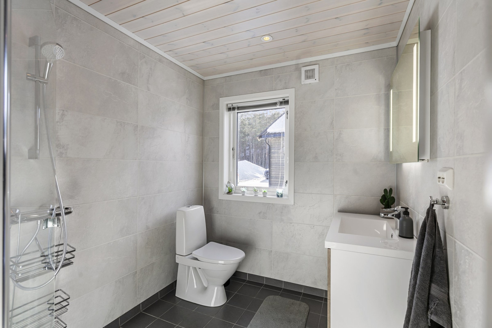 Badet er flislagt på gulv og våtromsplater på vegg Galleribilde