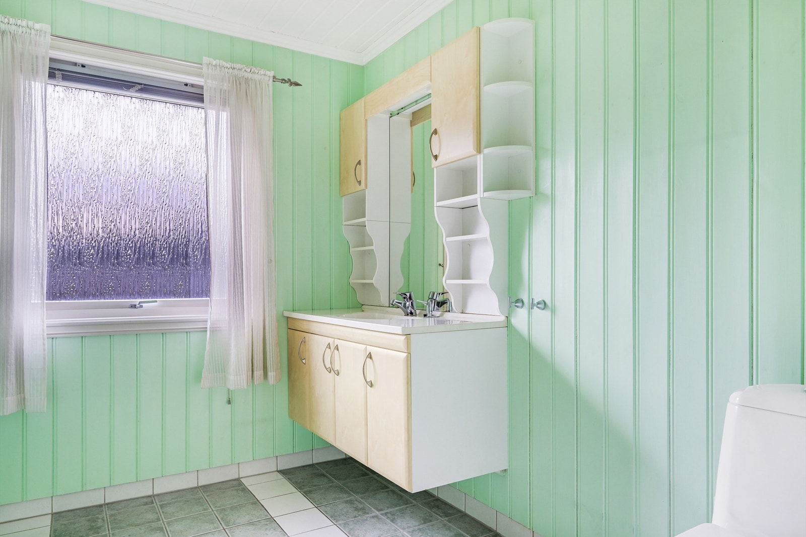 Badet har fliser i dusjsonen og malt panel på øvrige vegger. Gulvet er flislagt og har varmekabler. Galleribilde