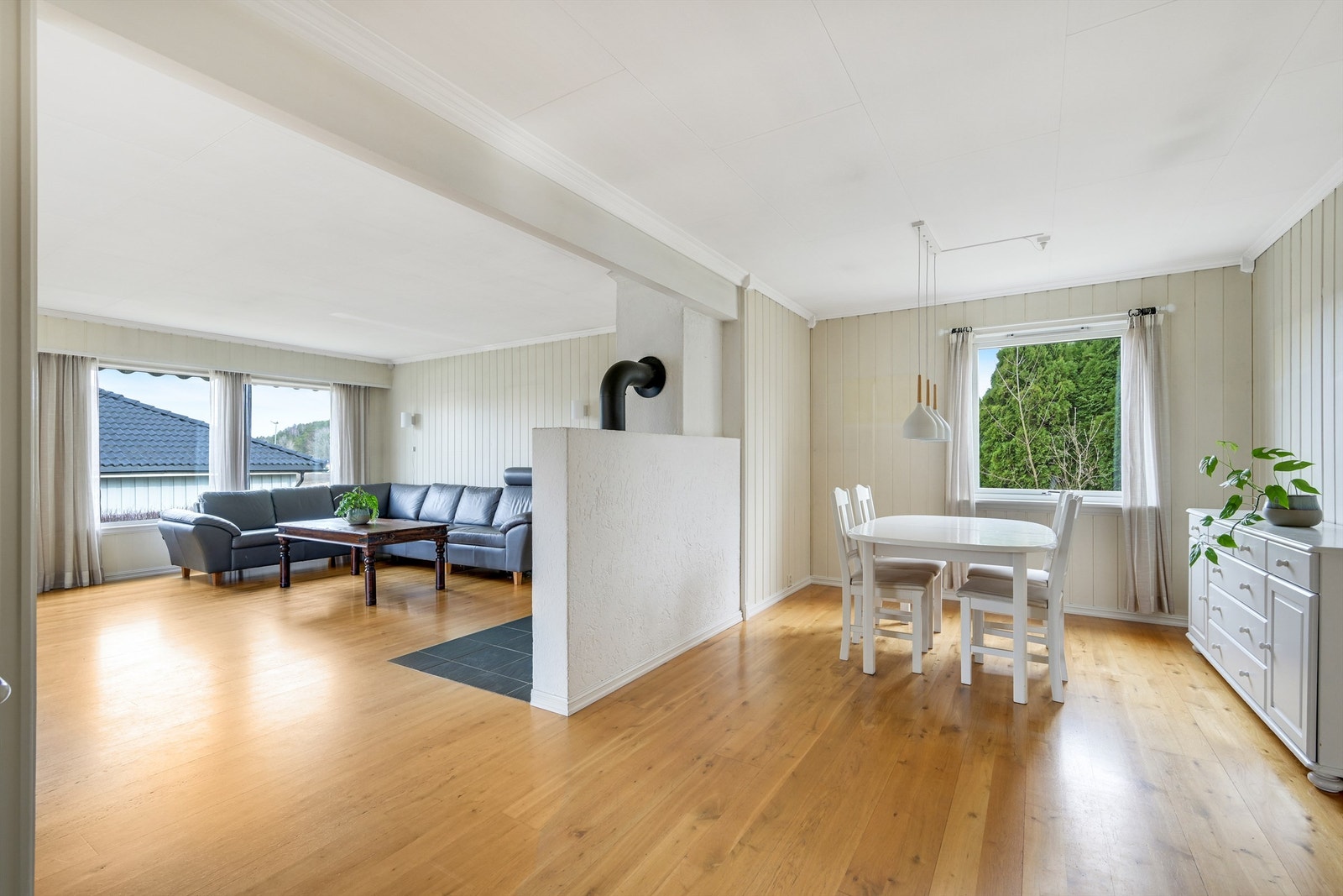 Stuen er romslig og delt av med plass til både sofagruppe og spisegruppe Galleribilde