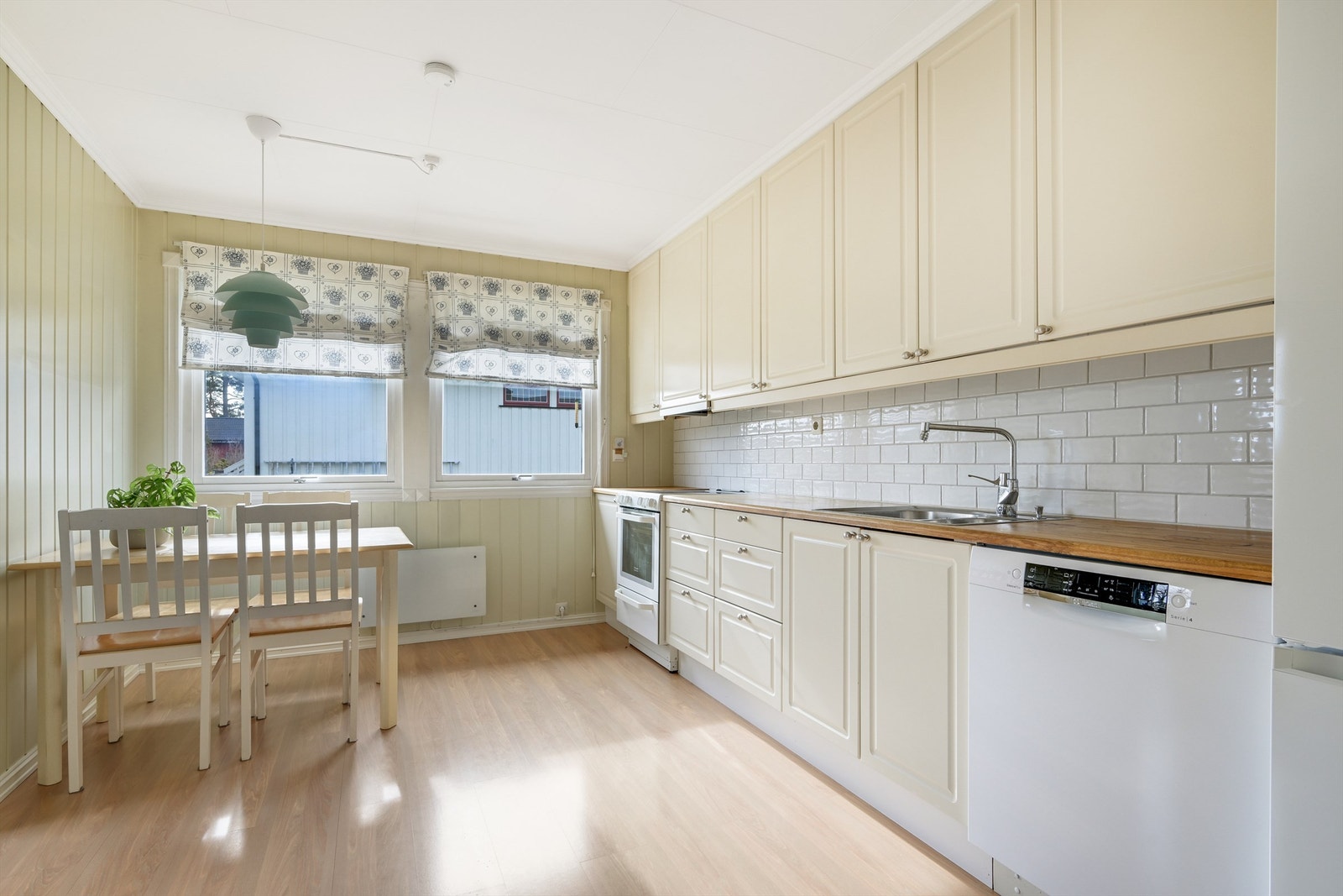 Koselig kjøkken med innredning med profilerte fronter og en benkplate i heltre. Det er god plass til en sittegruppe Galleribilde