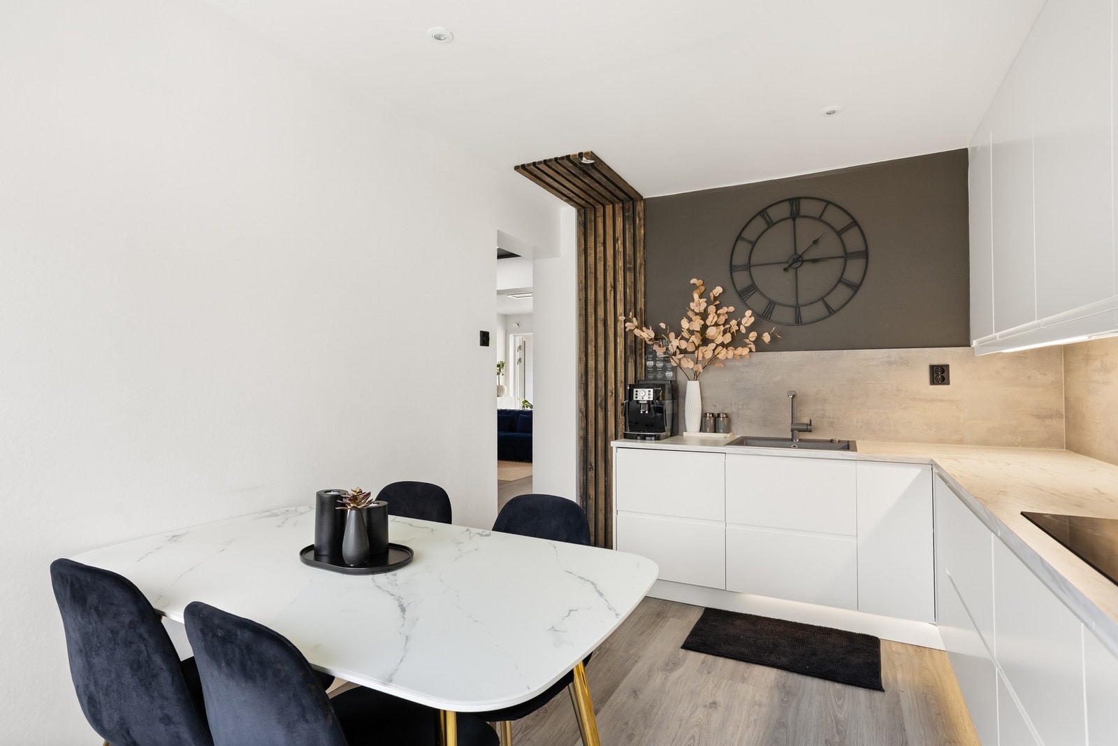 Moderne kjøkken med stilrene, hvite fronter og integrerte hvitevarer. Galleribilde
