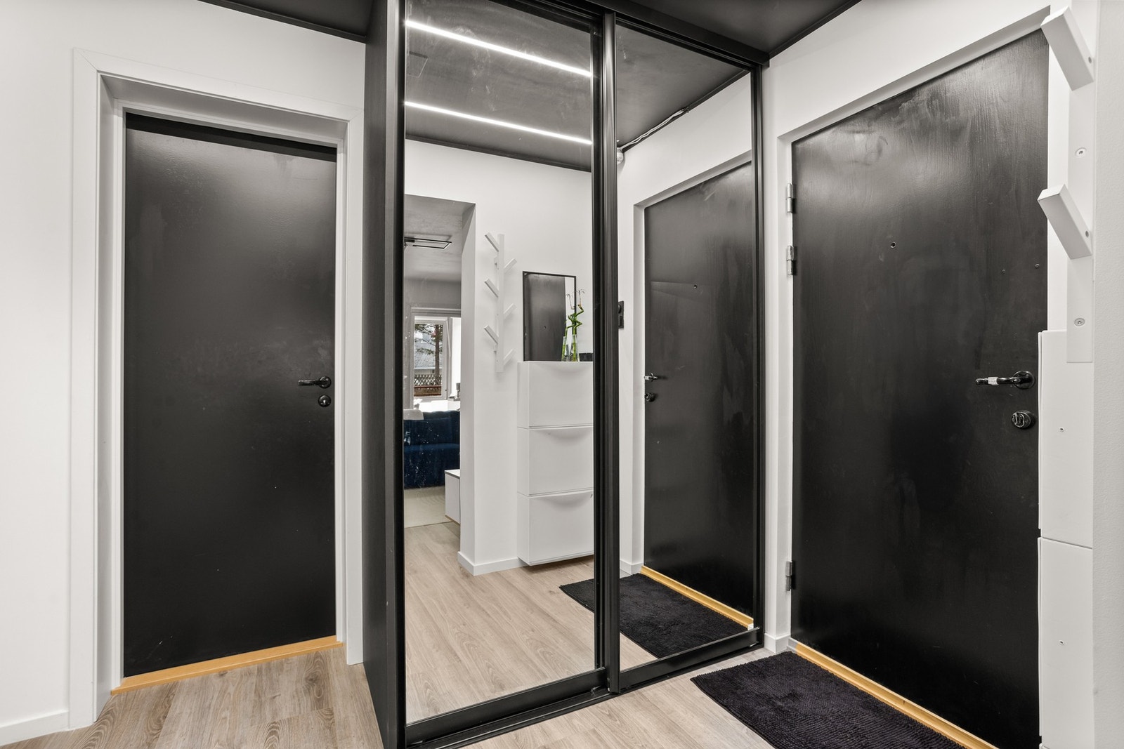Lys og romslig entré med praktisk skyvedørsgarderobe. Galleribilde