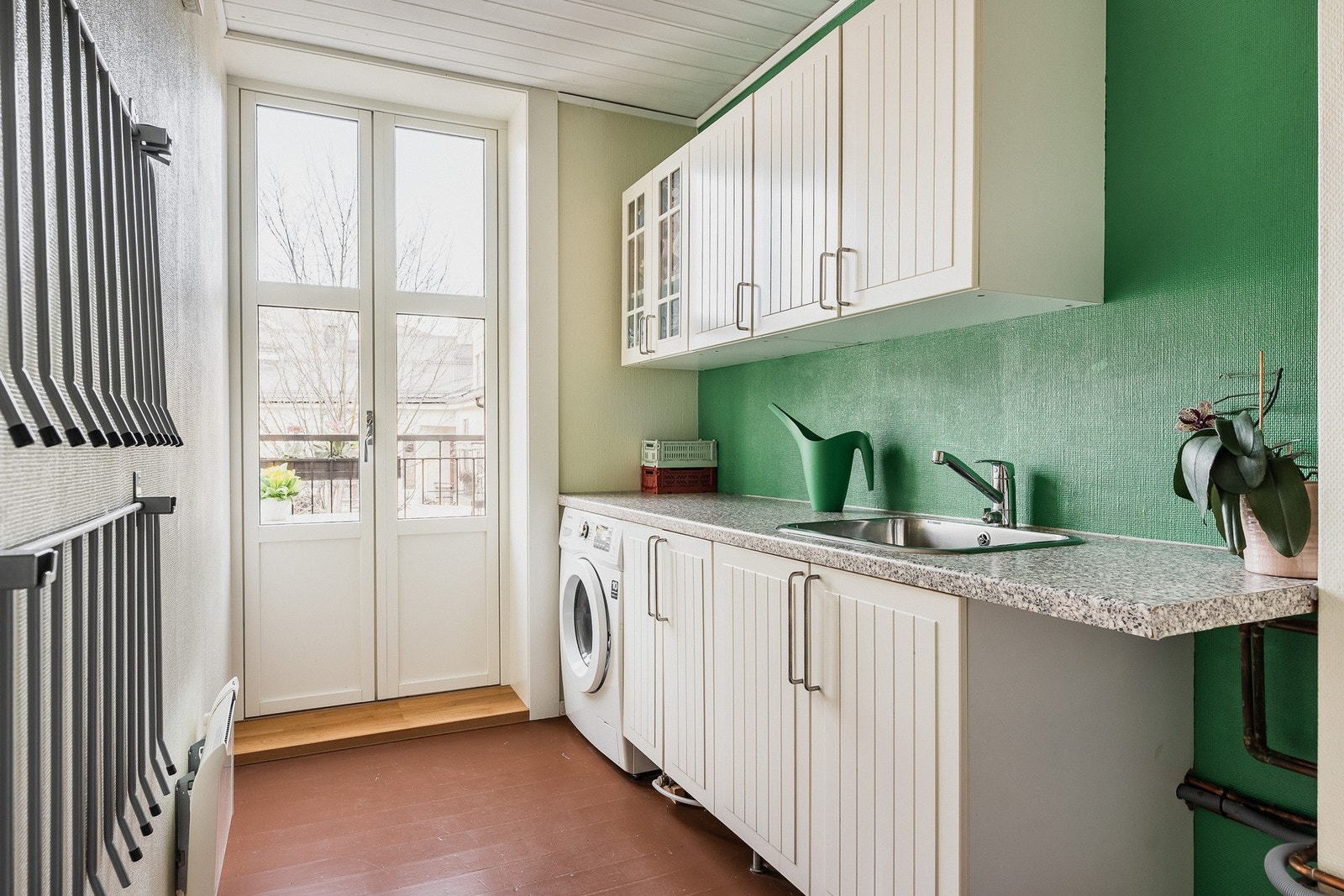 Grovkjøkken som benyttes som vaskerom, med utgang til balkong. Galleribilde