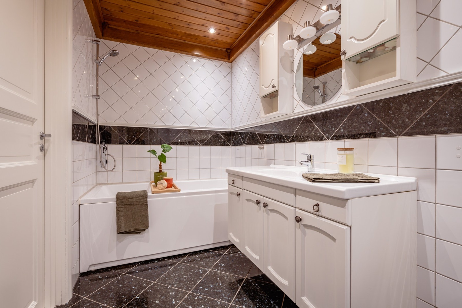 Badet utstyrt med et gulvfestet toalett og et badekar med dusjmulighet. Det er vifte i vegg og ventil i himling. Badet har opplegg for vaskemaskin. Galleribilde