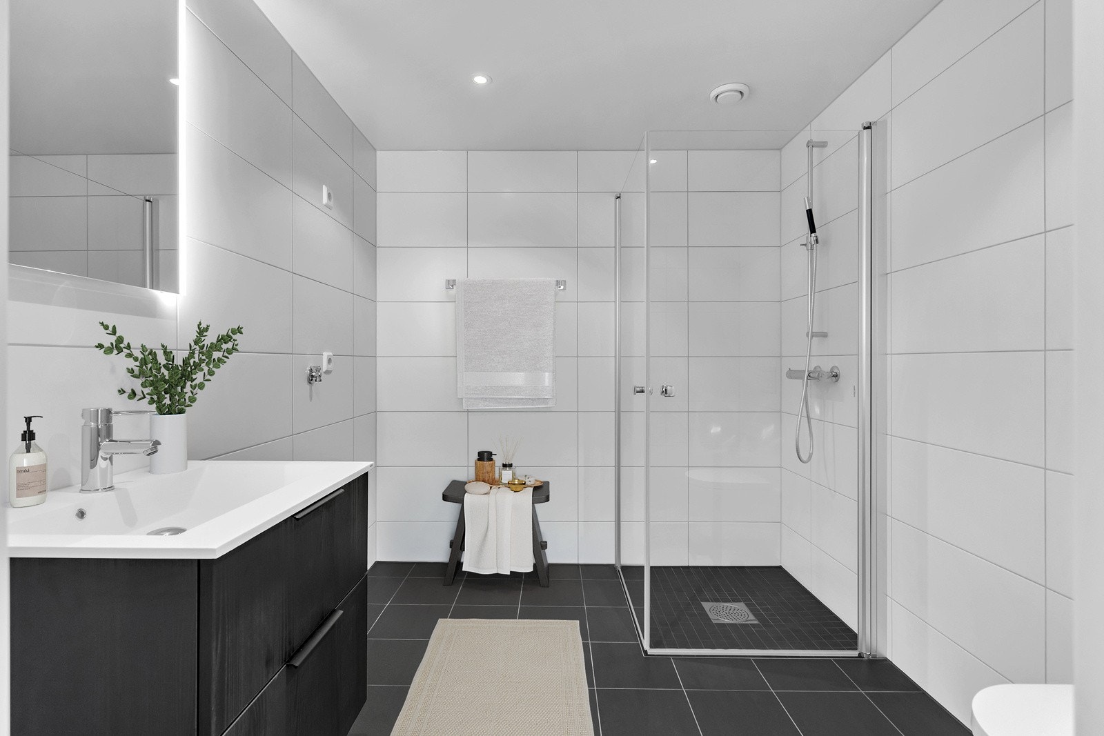 Flott bad med gulvvarme, dusj med glassdører, downlights og opplegg til vaskemaskin og tørketrommel. Leiligheten er digitalt stylet Galleribilde