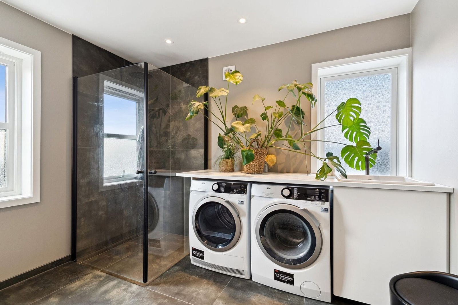 Praktisk innredet med dusj, toalett, servant, vaskemaskin og tørketrommel Galleribilde